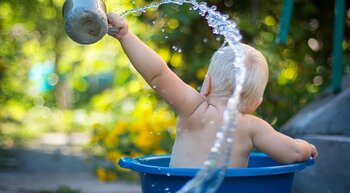 Kind plantscht mit Wasser